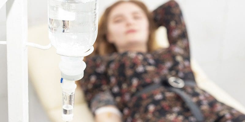 Closeup of saline drip with background Woman patient on the bed get better, when they come for treatment in room hospita NAD Therapy