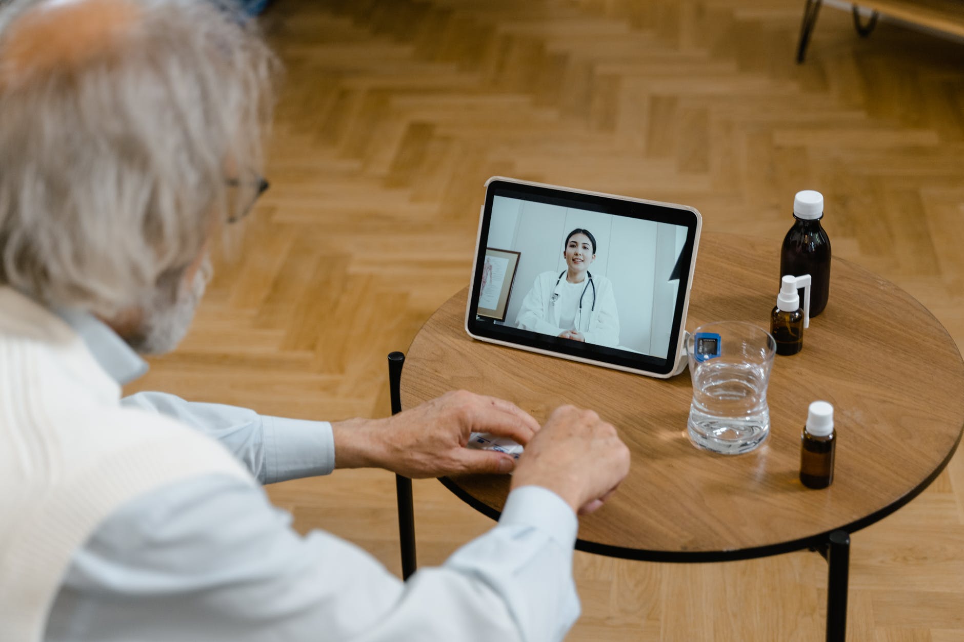 a old man talking with a lady doctor through tablet