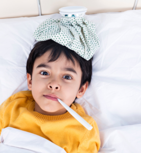 Child with thermometer in their mouth and ice pack on their head