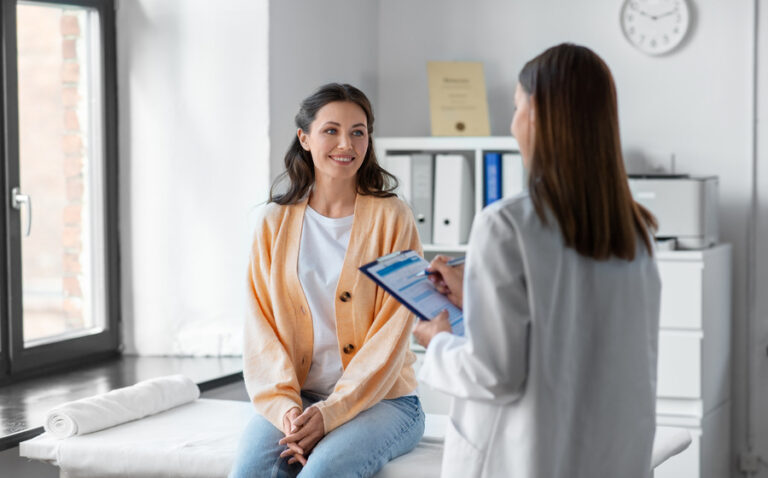 doctor with clipboard and woman at urgent care clinic