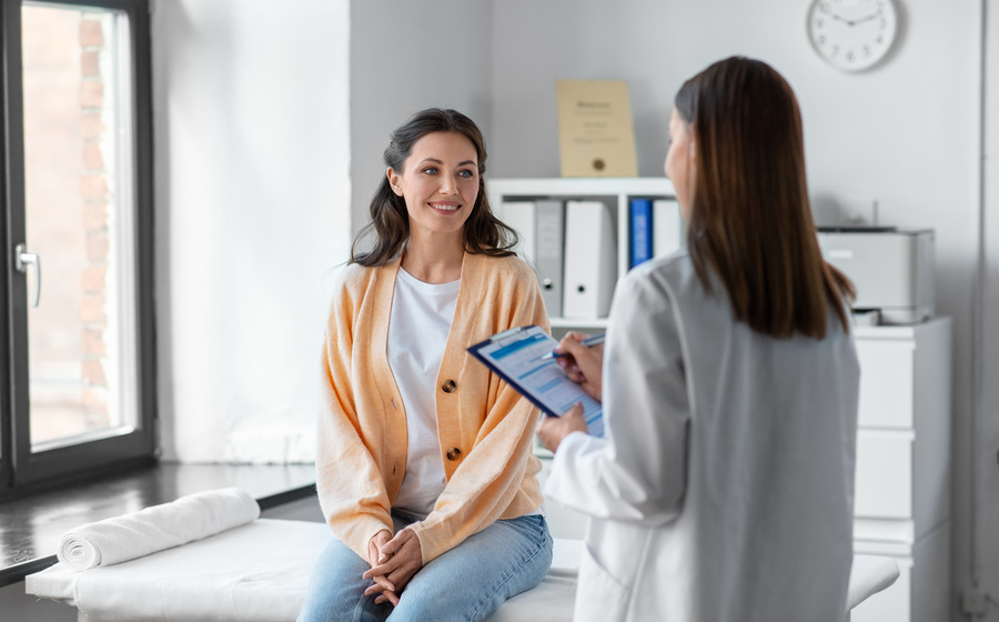 doctor with clipboard and woman at urgent care clinic
