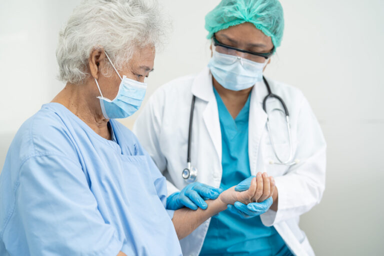 Doctor help elderly old woman patient wearing a face mask in hospital for protect safety infection.