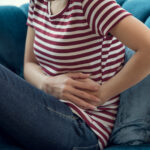 woman with stomatch ache hands touching her belly